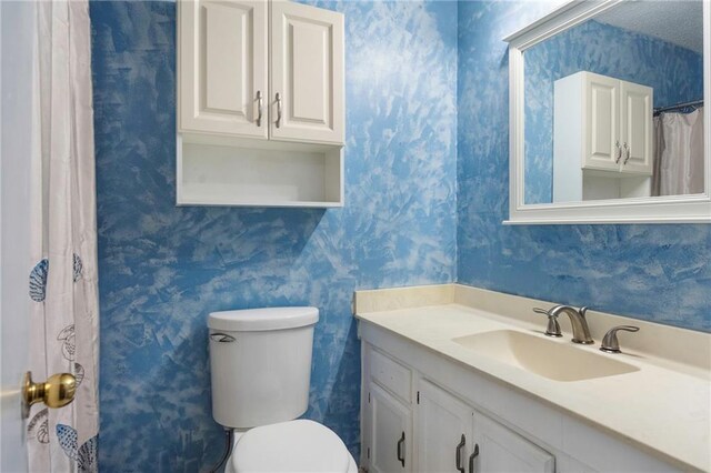 bathroom with vanity, a textured ceiling, and toilet