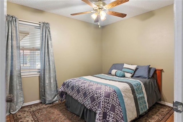 bedroom featuring ceiling fan, dark wood-type flooring, and a textured ceiling