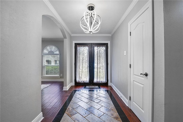 entryway featuring crown molding, baseboards, dark wood-type flooring, and french doors