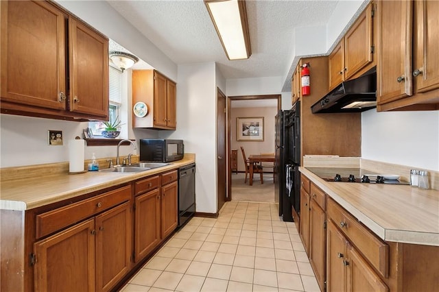 20 Cocodrie Ct, Kenner, LA 70065 - kitchen with light countertops, under cabinet range hood, brown cabinets, a sink, and black appliances
