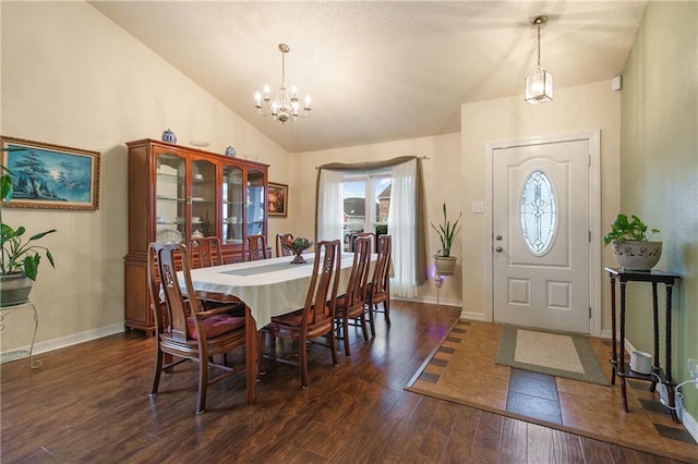 dining space featuring dark hardwood / wood-style flooring, high vaulted ceiling, and an inviting chandelier