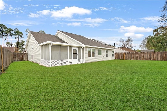 rear view of house featuring a sunroom and a yard