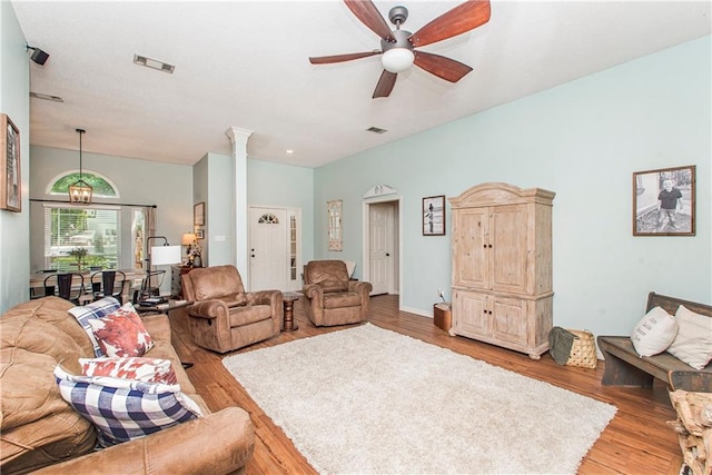 living room featuring hardwood / wood-style flooring, ceiling fan, and decorative columns