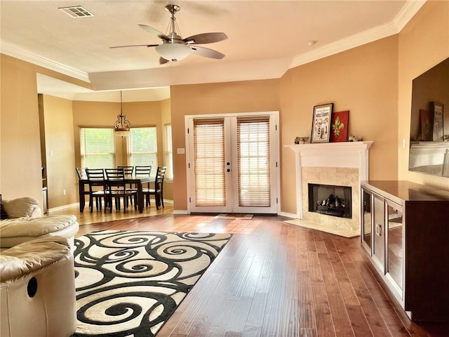 living room with hardwood / wood-style floors, ceiling fan, crown molding, and french doors