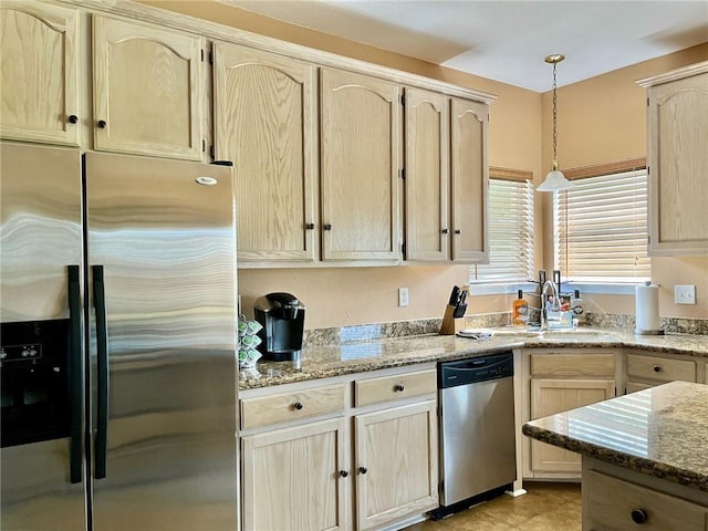 kitchen featuring decorative light fixtures, light stone countertops, stainless steel appliances, and light brown cabinetry