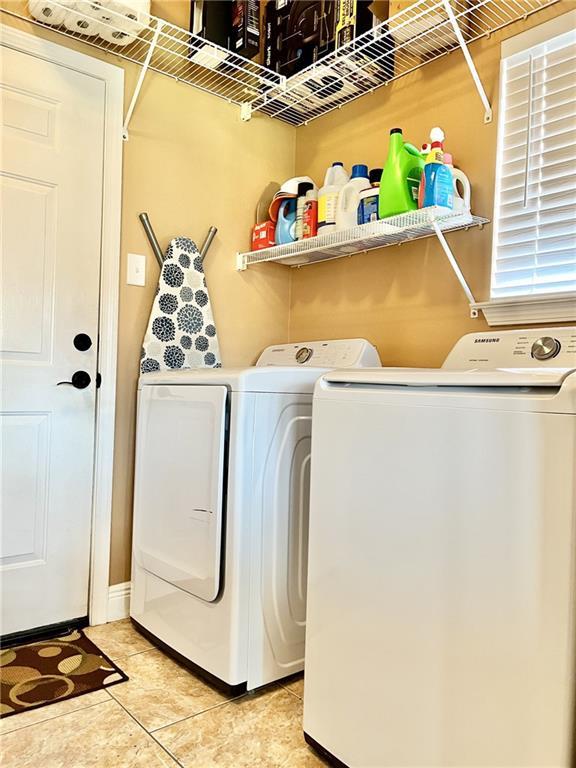 laundry area featuring tile patterned floors and washing machine and clothes dryer