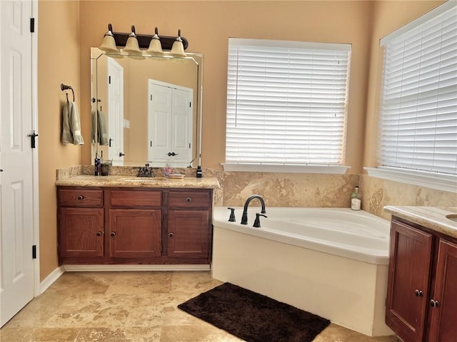 bathroom featuring vanity and a bath