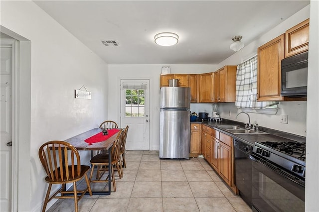 kitchen featuring light tile patterned floors, sink, and black appliances