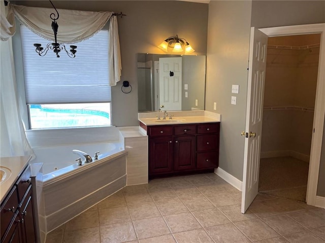 bathroom featuring tile patterned flooring, shower with separate bathtub, vanity, and a chandelier