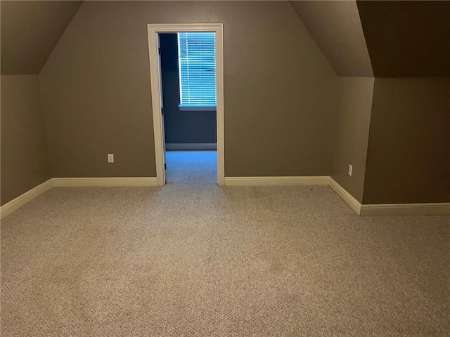 additional living space featuring carpet floors and vaulted ceiling