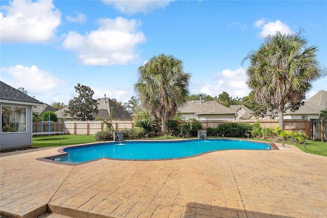 view of pool with pool water feature, a trampoline, and a patio