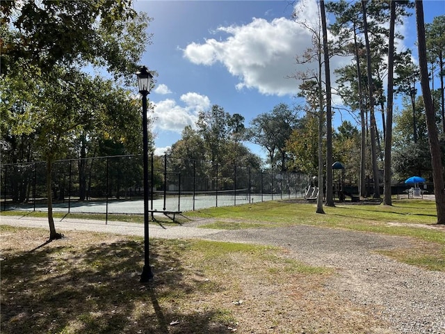 view of property's community with a water view and tennis court