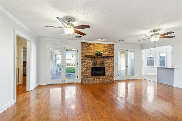 unfurnished living room featuring light wood-type flooring, a textured ceiling, and a wealth of natural light