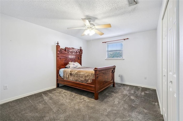 bedroom with a textured ceiling, a closet, dark carpet, and ceiling fan