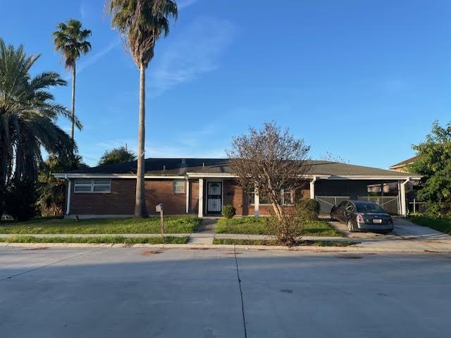 ranch-style home featuring a front yard and a carport