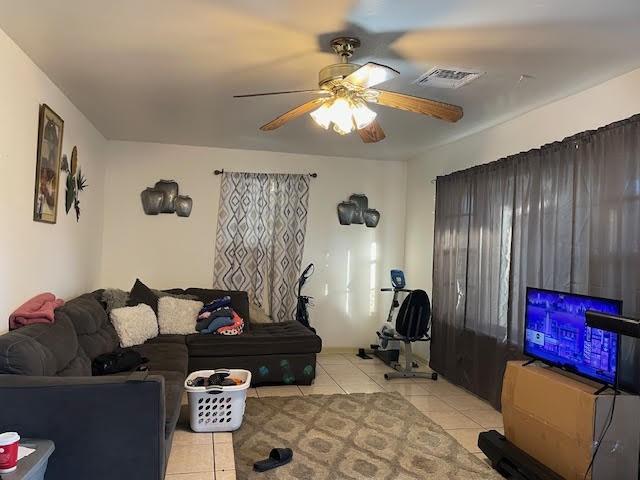 tiled living room featuring ceiling fan