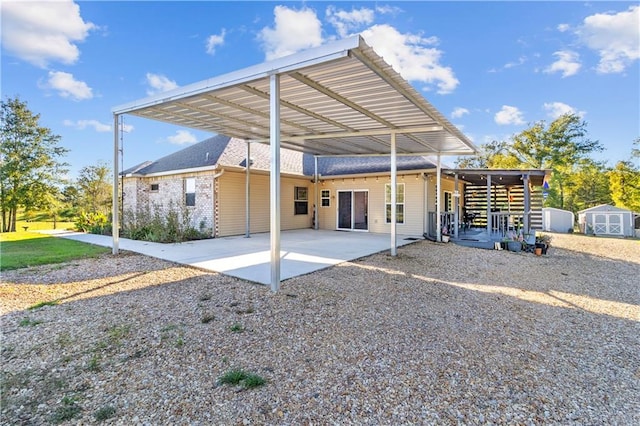 rear view of property with a shed and a carport