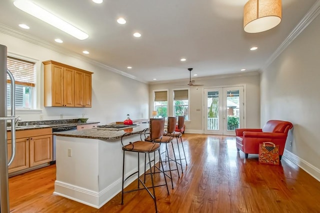 kitchen featuring pendant lighting, ornamental molding, light hardwood / wood-style floors, and a kitchen island