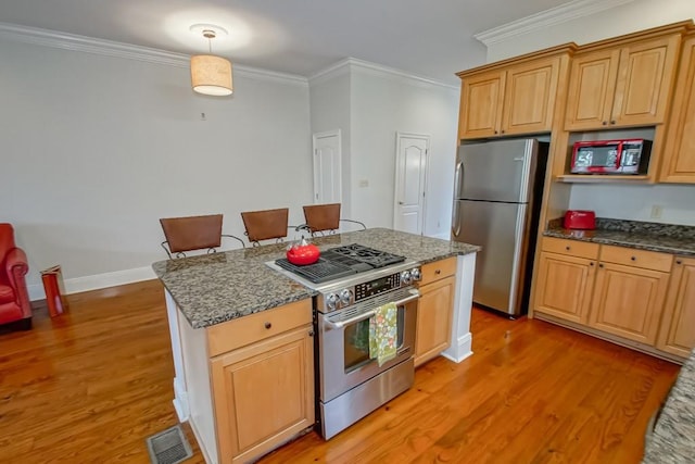 kitchen featuring ornamental molding, appliances with stainless steel finishes, pendant lighting, and light hardwood / wood-style floors