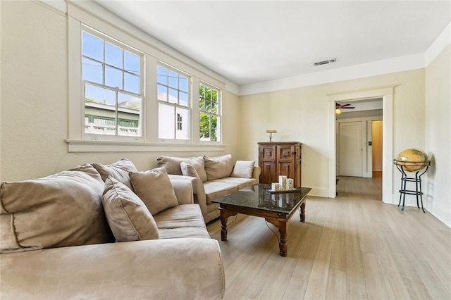 living room with ceiling fan and light hardwood / wood-style flooring