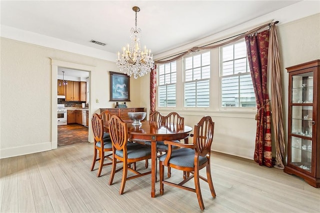 dining room featuring light hardwood / wood-style flooring and an inviting chandelier