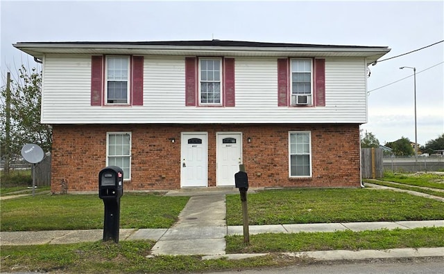 view of front of property featuring a front yard and cooling unit