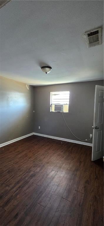 unfurnished room with a textured ceiling and dark wood-type flooring