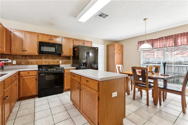 kitchen with tasteful backsplash, black appliances, pendant lighting, light tile patterned floors, and a center island