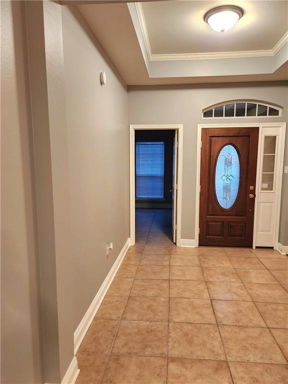 foyer featuring light tile patterned floors and ornamental molding