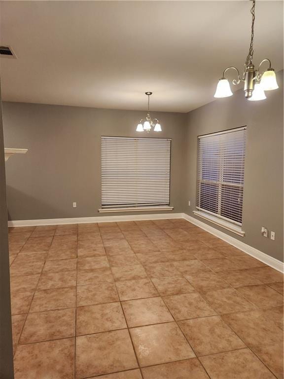 unfurnished dining area with light tile patterned floors and an inviting chandelier