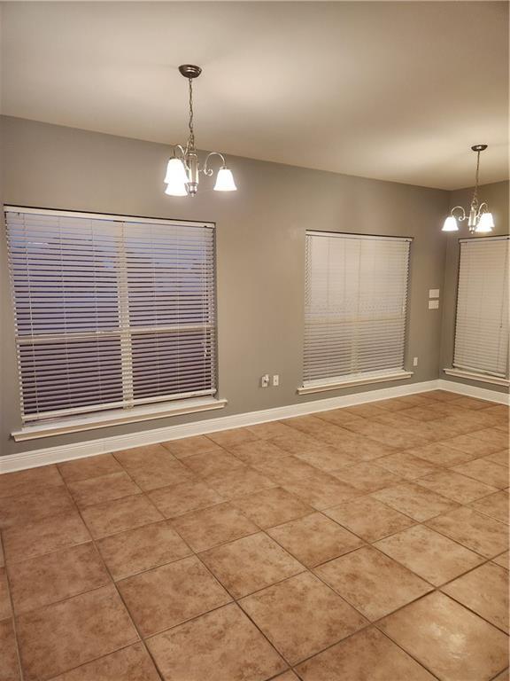 unfurnished dining area with light tile patterned floors and an inviting chandelier