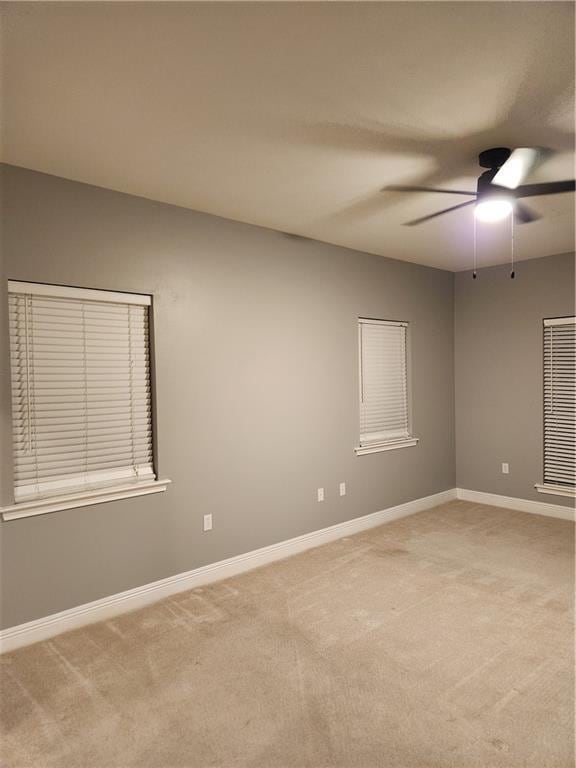 spare room featuring ceiling fan and light carpet