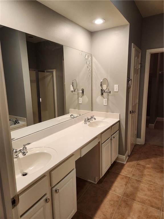 bathroom featuring tile patterned flooring, vanity, and shower with separate bathtub