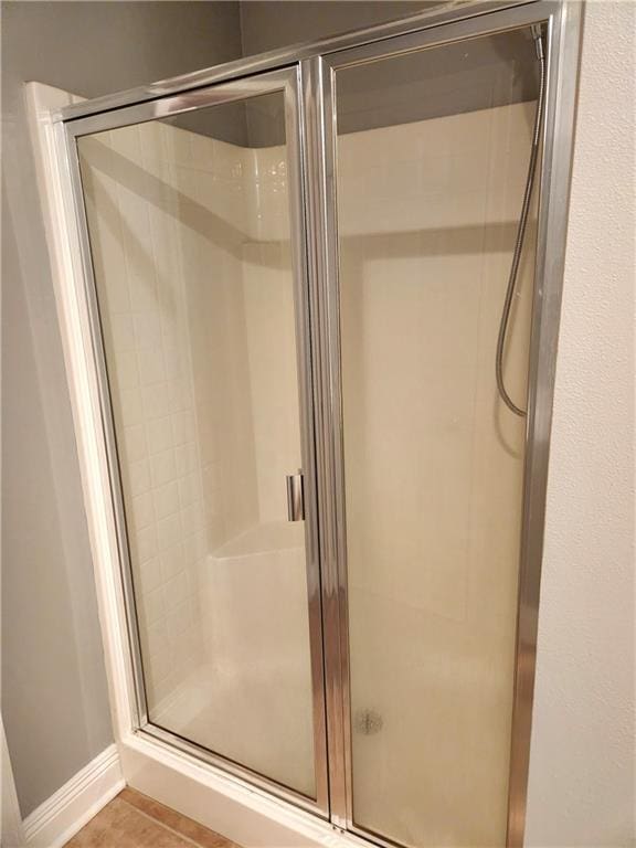 bathroom featuring tile patterned flooring and a shower with shower door