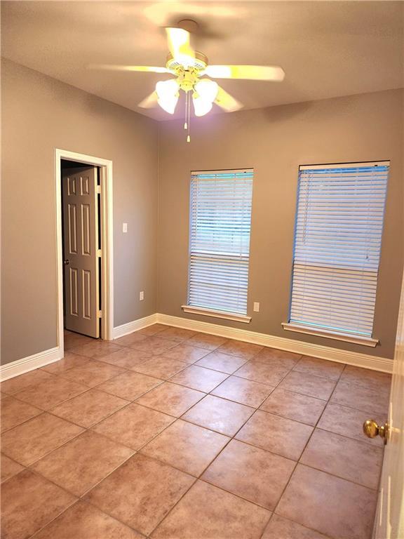 unfurnished room featuring ceiling fan and light tile patterned floors