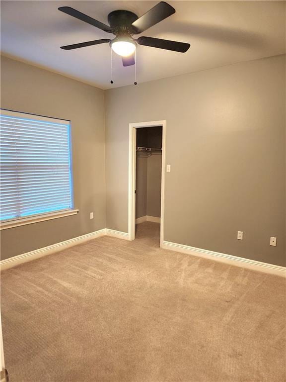 carpeted empty room featuring ceiling fan