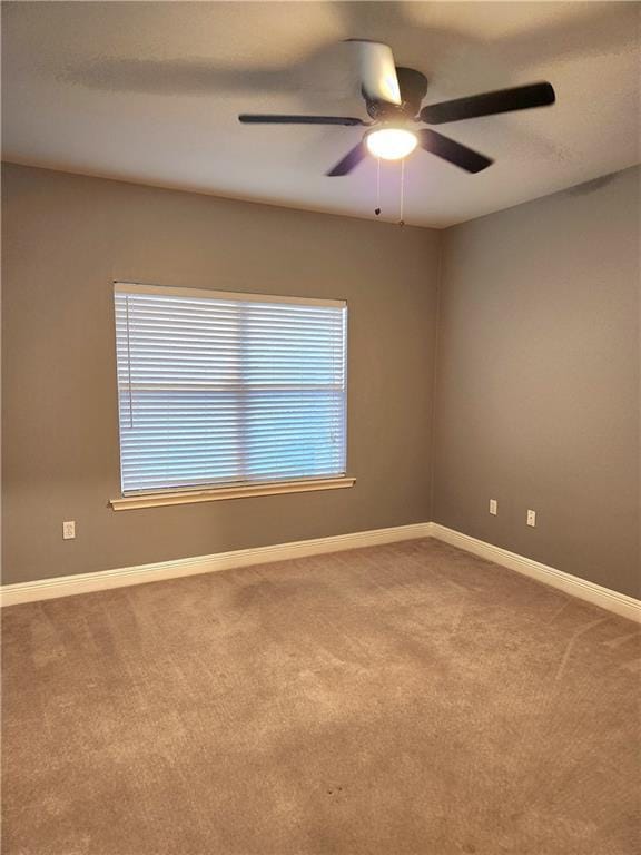 spare room featuring carpet floors, a wealth of natural light, and ceiling fan