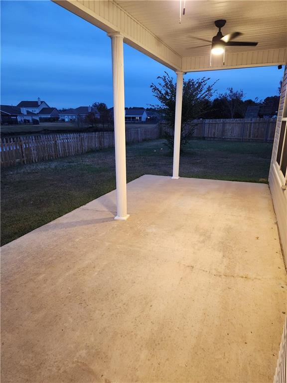 patio terrace at dusk featuring ceiling fan