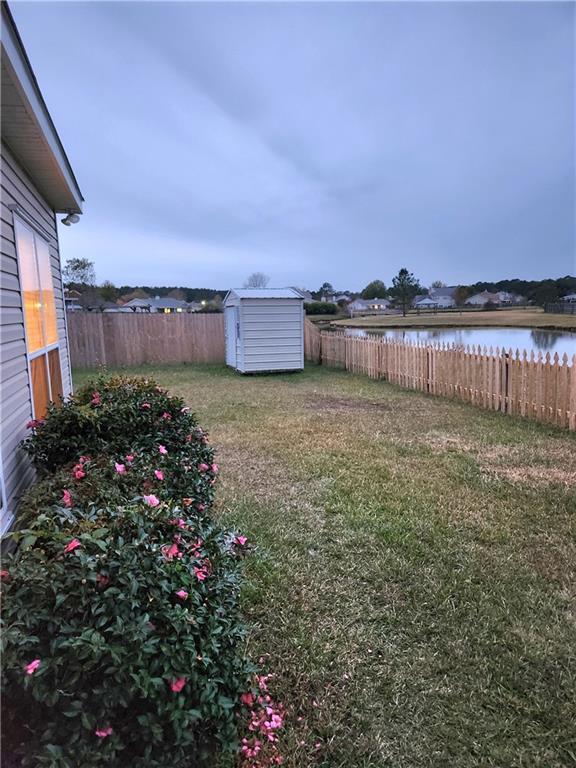 view of yard featuring a water view and a storage unit