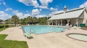 view of swimming pool with a patio and a hot tub