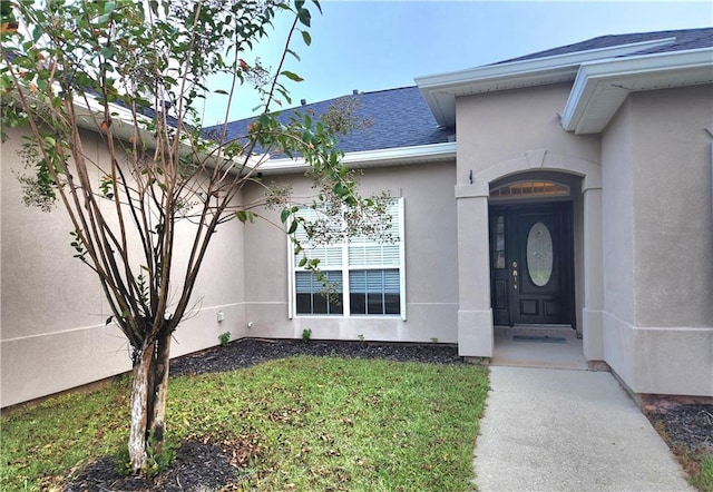 property entrance with a lawn