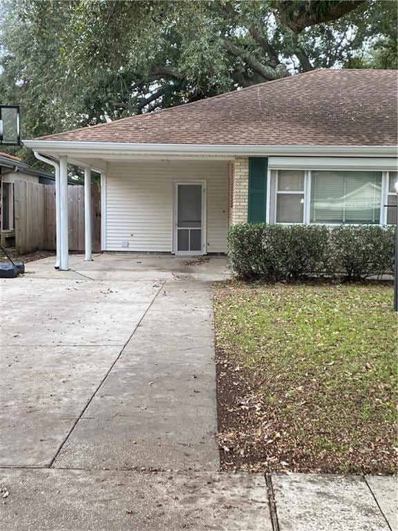 single story home featuring a carport and a front yard