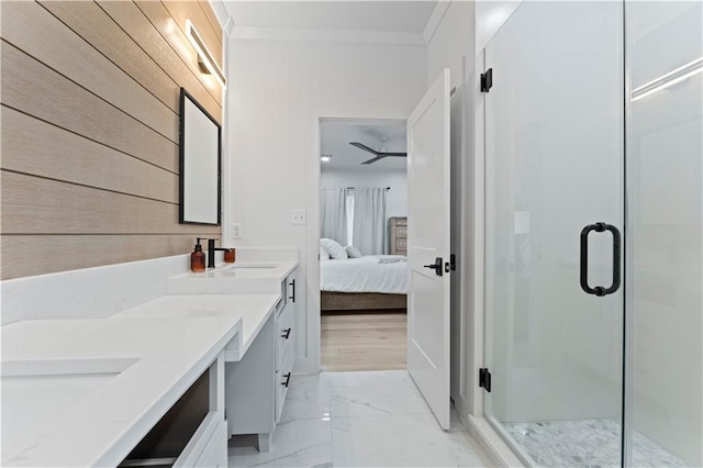 bathroom featuring vanity, a shower with shower door, and crown molding