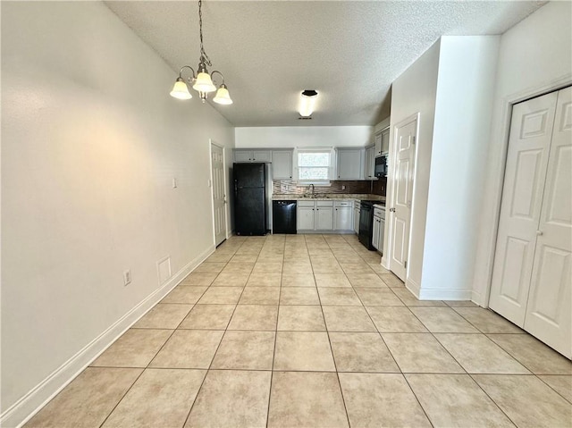 kitchen with light tile patterned flooring, an inviting chandelier, gray cabinetry, and black appliances