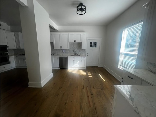 kitchen with dishwasher, white cabinets, light stone countertops, tasteful backsplash, and dark hardwood / wood-style flooring