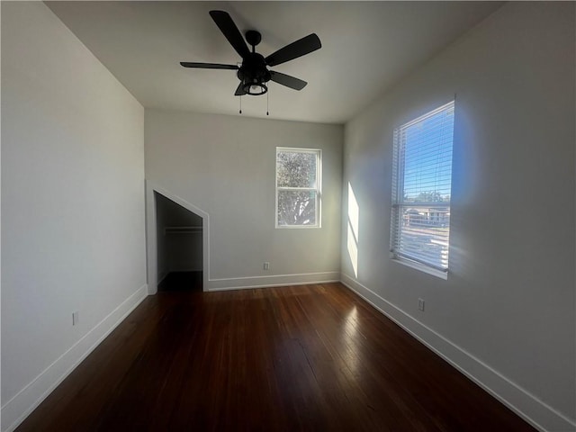 unfurnished living room featuring dark hardwood / wood-style flooring and ceiling fan