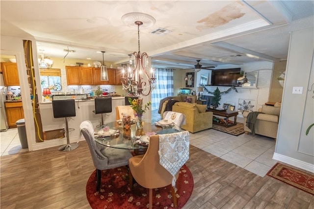 dining room with ceiling fan with notable chandelier, a healthy amount of sunlight, light wood-type flooring, and crown molding