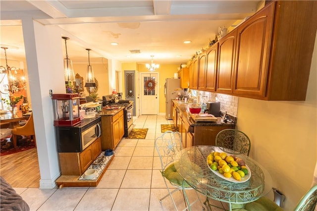 kitchen with backsplash, decorative light fixtures, stainless steel appliances, and a chandelier