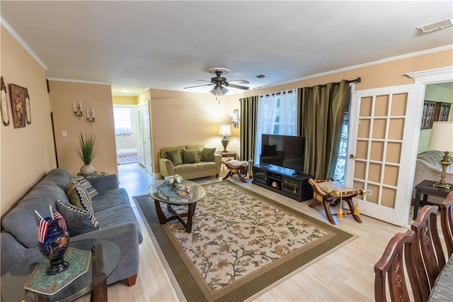 living room with ceiling fan, wood-type flooring, and ornamental molding