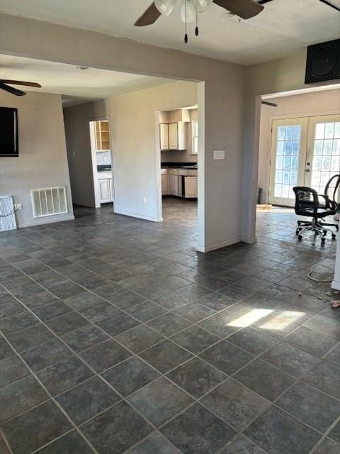 unfurnished living room with ceiling fan and french doors